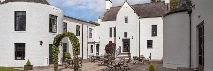 The pretty outside of the 4 star Maryculter House Hotel in Aberdeenshire, showing the courtyard sitting area which overlooks the River Dee.